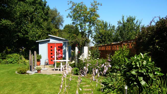 Gartenhaus mit Pergola und Pflasterrondell