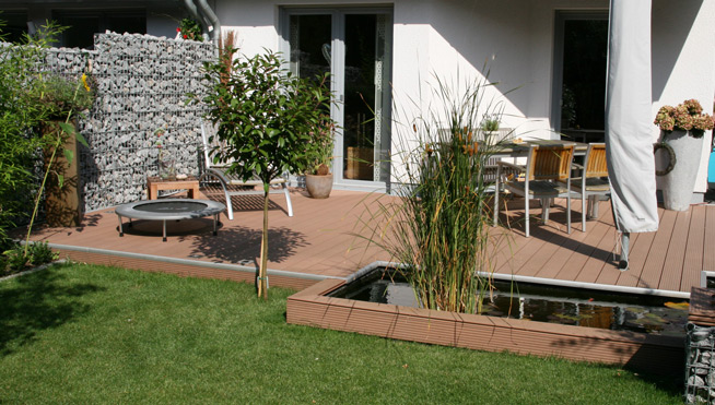 Terrasse mit Sichtschutz aus einer Gabbionenwand.